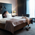 Kengät lattialla parivuoteen edustalla