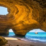 Näkymä Benagilin luolasta merelle, jossa seilaa purjelaiva.