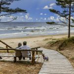 PAriskunta istuu penkillä merelle katsellen