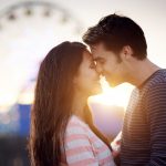 Pariskunta halailee maailmanpyörän edessä