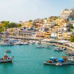 Mikrolinamo-venesatama. Veneitä laiturissa ja rakennuksia rinteessä.