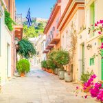 Värikäs tyhjä kuja, kukkaruukkuja seinustalla