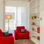 Kaksi punaista nojatuolia ja kirjahylly