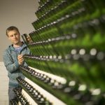 Vihreitä siideripulloja rivissä seinällä