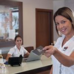 Nainen näyttää hotelliavainta vastaanottotiskillä