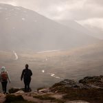 Kaksi naista kulkee vaellusreittiä sumuisessa säässä.