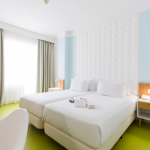 Vaaleansävyinen huone kahdella vuoteella