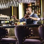 Baarimikko kaataa juomia laseihin