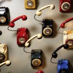 Erivärisisä puhelimia seinällä