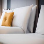 Tyynyjä sängyllä. Keltainen koristetyyny