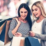 Kaksi naista ihastelee ostoskassien sisältöä.