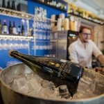 Viinipullo jääastiassa baaritiskillä, taustalla baarimikko.