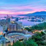 Näkymää Malagan kaupunkiin ja satamaan illan hämärtyessä.