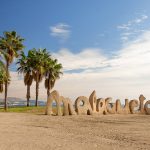 Malagueta-teksti patsasmuodostelmana rannalla.