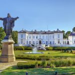 Palangan meripihkamuseon kartanorakennus ja puisto, vasemmalla käsiä levittävä patsas.