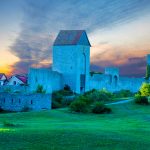 Visbyn linnan muuri, vihreä nurmi ja taivas auringonnousun aikaan.