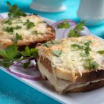 Kaksi juustolla kuorrutettua paahdettua leipää vadilla.