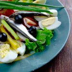 Anjovista ja kananmunia salaattilautasella.