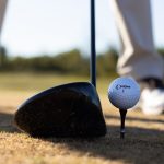 Henkilö lyömässä golfpalloa