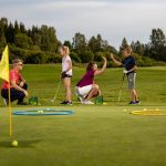 Lapsia ja aikuisia golfaamassa