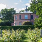 Vaaleanpunainen rakennus Rosendalin linnan puutarhassa