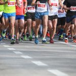 Ryhmä juoksijoita asfalttitiellä.