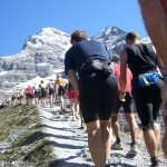 Ryhmä ihmisiä nousemassa rinnettä.