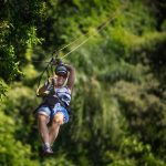 Hymyilevä nainen laskemassa ilmaköysiradalla.