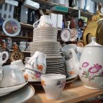 Paljon erilaisia vanhoja astioita ja kodin esineitä.