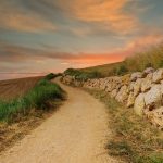 Hiekkainen vaelluspolku auringonlaskun aikana.