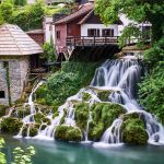 Vesiputous laskee jokeen rakennusten lomassa.