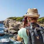 Vaeltaja ottaa kuvaa merenrannasta.