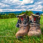 Lähikuva vaelluskengistä ruohikolla.