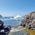 Aalto menee uimarin yli luonnon uima-altaalla Los Gigantesissa