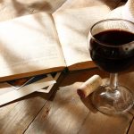 Punaviinilasi ja kirja.