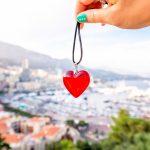 Punainen sydän roikkuu Monacon maisemaa vasten.