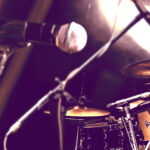 Mikrofoni ja rummut komeilevat esiintymislavalla.