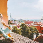 Nainen ihailee näköalapaikalla Tallinnaa kesäisessä säässä