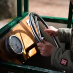 Lapsi ohjaa kulkuneuvoa ratista.