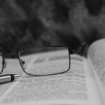 Silmälasit on jätetty avoimen kirjan päälle.