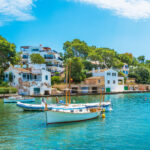 Veneitä kiinnitettynä rantaan kylän edustalla aurinkoisena päivänä.