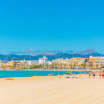 Uimaranta kuvattuna kirkkaana päivänä, taustalla näkyy kerrostaloja ja vuoristoa.