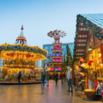 Alexanderplatzin joulutorilla valaistu karuselli ja myyntikoju