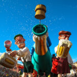 Nizzan Mardi Gras -karnevaalikulkueen hahmoissa suuri avattu kuohuviinipullo sekä olutta juovia mieshahmoja