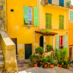 Kirkkaan keltainen talo ja kapea keskiaikainen kuja Villefranche-sur-Merin kylässä