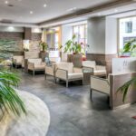 Hotel de Sueden sisääntuloaulassa useita tuoleja ja kukkia