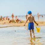 Lapsi ämpärin kanssa Jurmalan hiekkarannalla