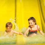 Kaksi pientä lasta vesiliukumäessä