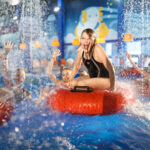 Lapset leikkivät vesipuiston allassuihkussa