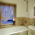 Kylpyhuoneessa on kylpyamme ja kaunis vaaleanpunainen kaakeli.